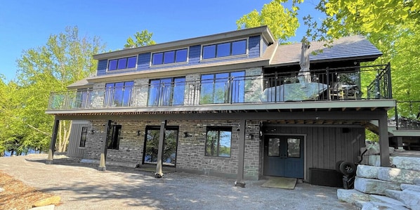 Ein zweistöckiges Haus mit Balkon, Steinhausfassade und Garage.
