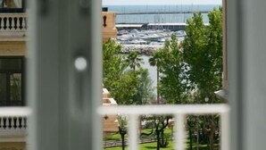 A view from a balcony overlooking a marina with boats, a bridge, and a clear sky. - Divina Salerno (Salerno)