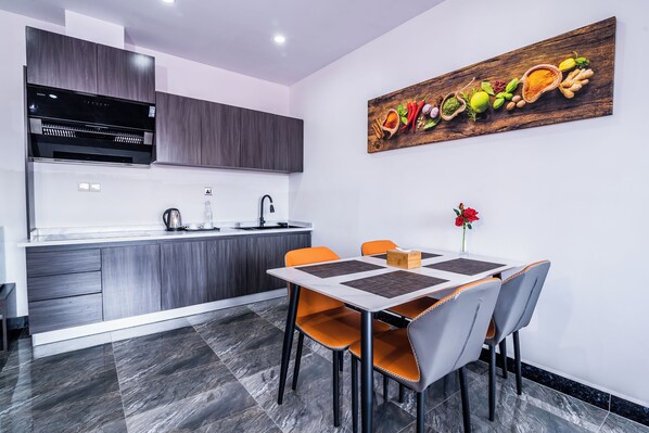 A modern kitchen with dark wood cabinets, a stainless steel range hood, and a white countertop.
