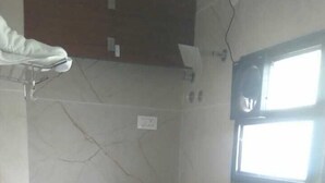 A small, tiled bathroom with a shower, toilet, and a window. - Shelke Mama's Lodging & Resorts (Chhatrapati Sambhajinagar)