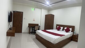 A bedroom with a wooden bed, a desk, and a wardrobe. - Shelke Mama's Lodging & Resorts (Chhatrapati Sambhajinagar)