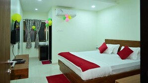 A hotel room with a bed, a bedside table, a TV, and a window with curtains. - Shelke Mama's Lodging & Resorts (Chhatrapati Sambhajinagar)