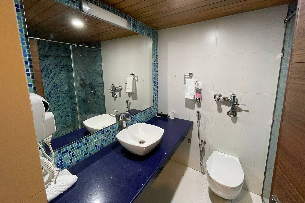 A bathroom with two sinks, a mirror, and a shower.