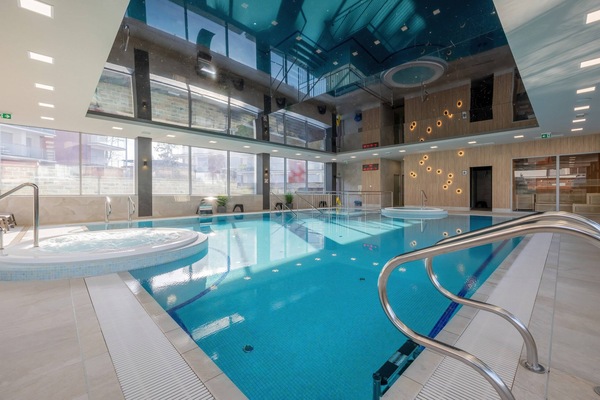 An indoor swimming pool with a sleek, modern design and plenty of sunlight.