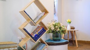 A wooden bookshelf with books and a vase of flowers. - Spacious Family Cottage Near Prague – Pool, Sauna, Garden & Great Day Trips (Mneteš)
