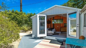 Una casa pequeña y de un solo nivel, con la puerta abierta que da a un dormitorio.