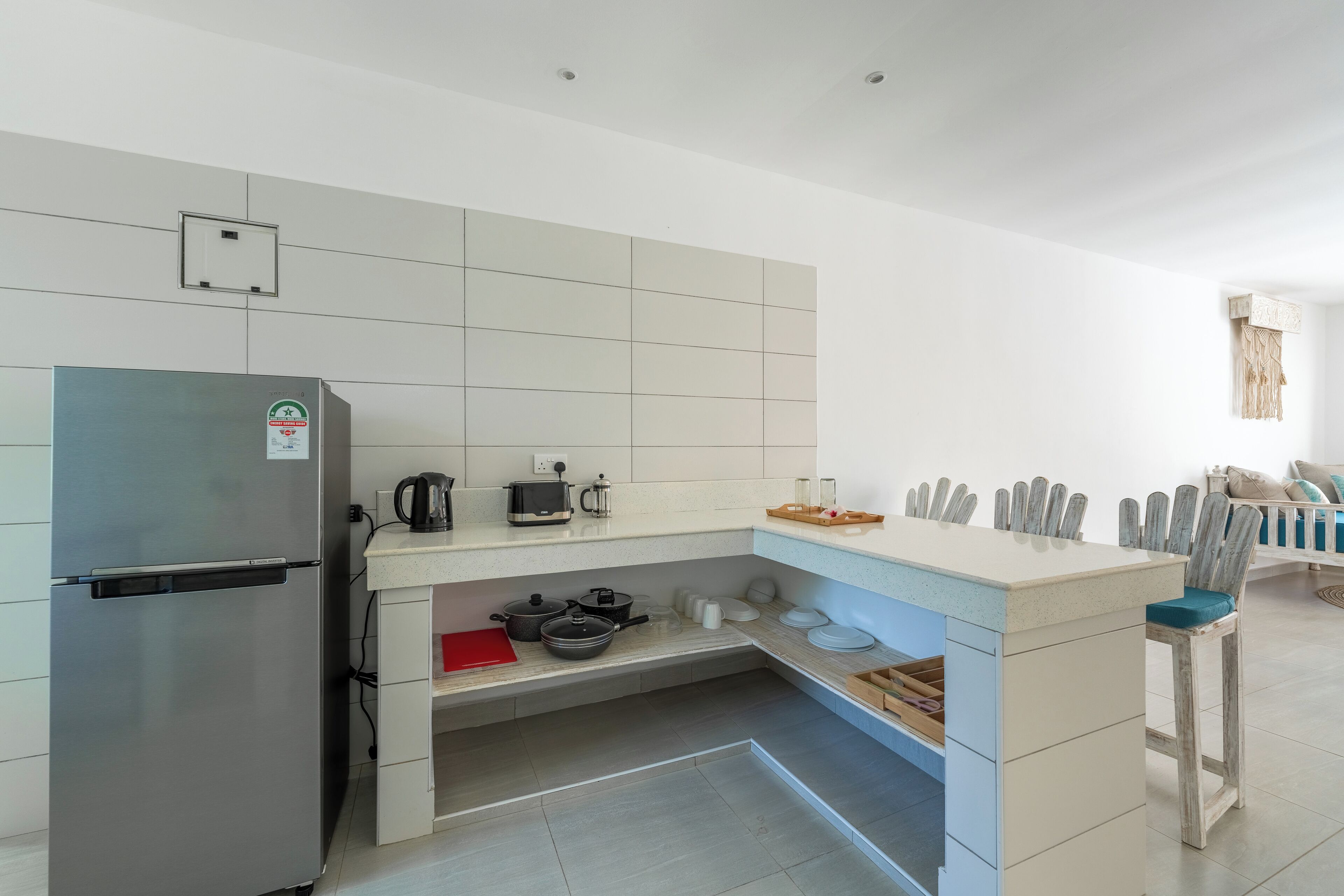Een moderne keuken met een ingebouwde koelkast, een koffiezetapparaat en een waterkoker op het aanrecht.