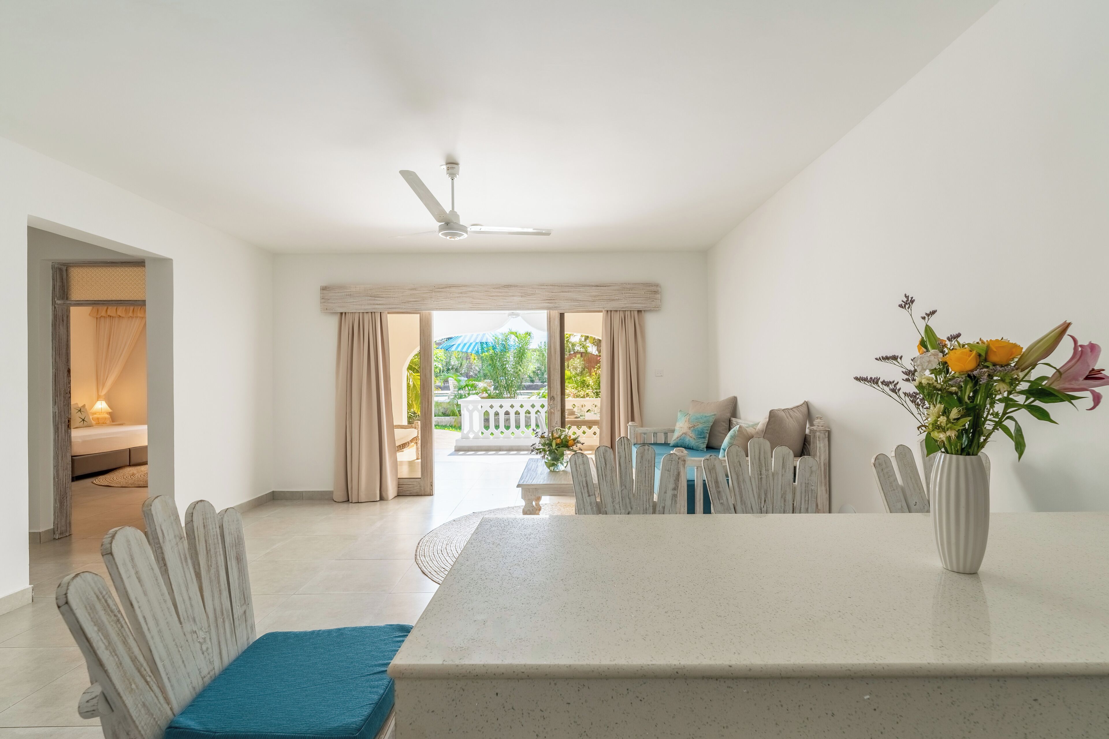 A spacious room with a dining table, chairs, and a view of the outdoors.