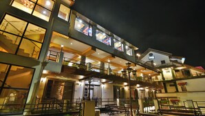 A multi-story hotel with outdoor seating areas and a balcony.