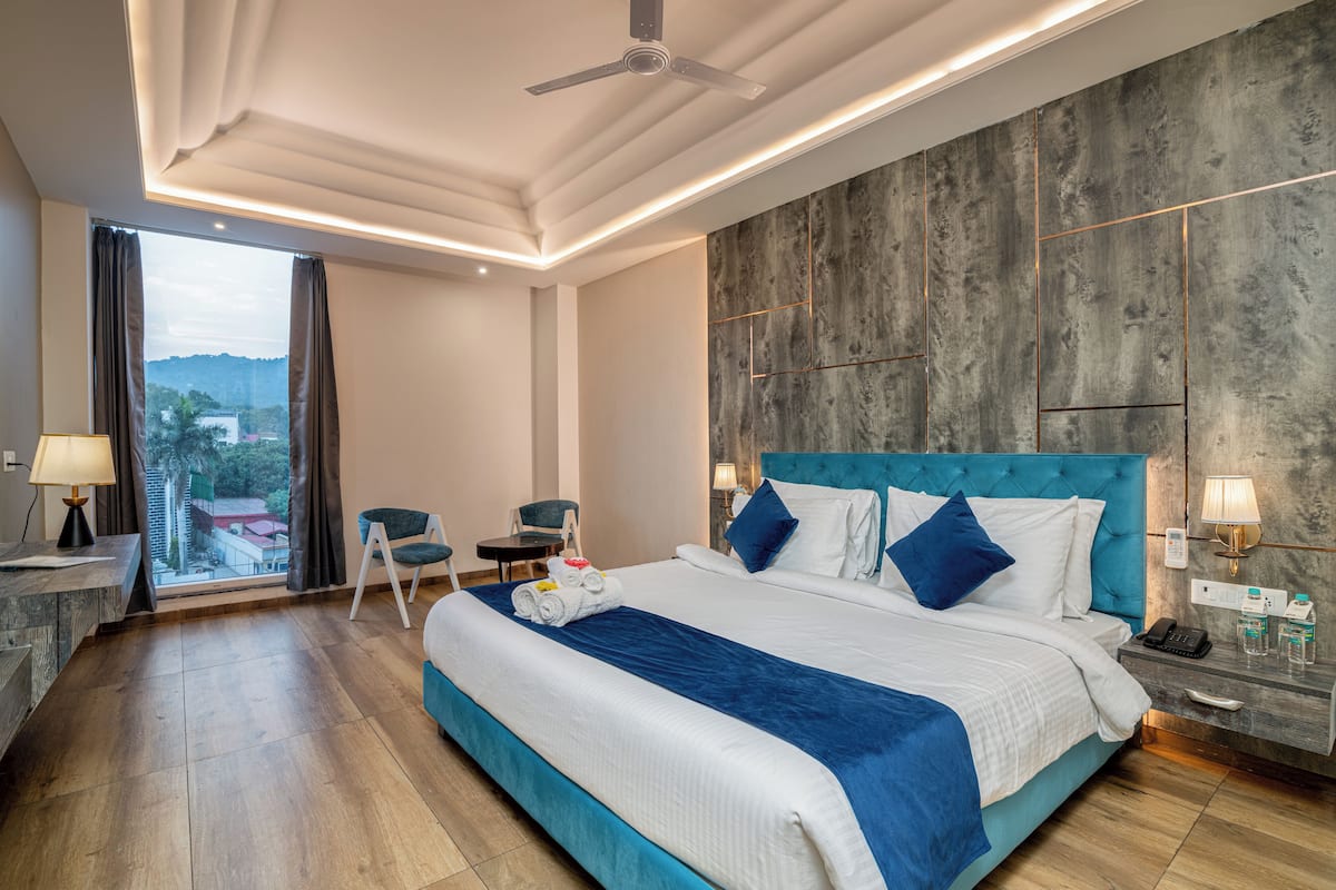 Un hotel moderno con una cama grande, un escritorio, una silla y vistas al exterior.