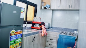 Una cocina con refrigerador, estufa y pileta.