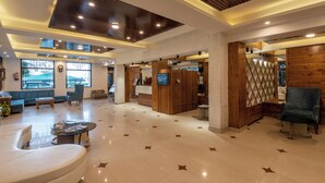 A spacious lobby with a modern design, featuring a reception desk, seating area, and large windows. - Meghavan Resort By DLS Hotels (Dharamshala)