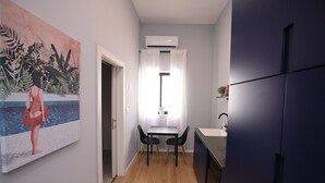 A compact kitchen with a dining area, a refrigerator, and a window with curtains. - Stylish apartment in central TLV just a short walk from the beach (Tel Aviv)