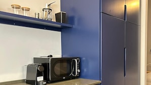 A compact kitchen with a microwave, coffee maker, and dishwasher. - Stylish apartment in central TLV just a short walk from the beach (Tel Aviv)