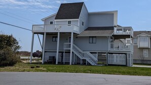A two-story house with a balcony, a covered porch, and a staircase leading to the upper level. - 5 Bedroom Dog Friendly House with community pool and beach views! (Fenwick Island)