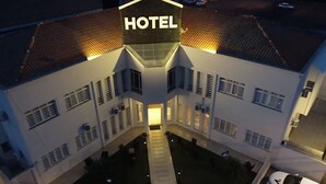 Un hotel con un patio central, numerosas ventanas y un letrero llamativo que dice 'HOTEL'.