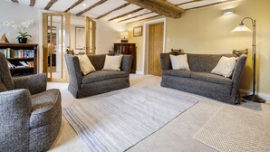 A living room with two grey sofas, a wooden ceiling, a bookshelf, and a floor lamp. - Joe's Cottage -  Modern, yet cosy, two bedroom cottage - Brigsteer (Brigsteer)