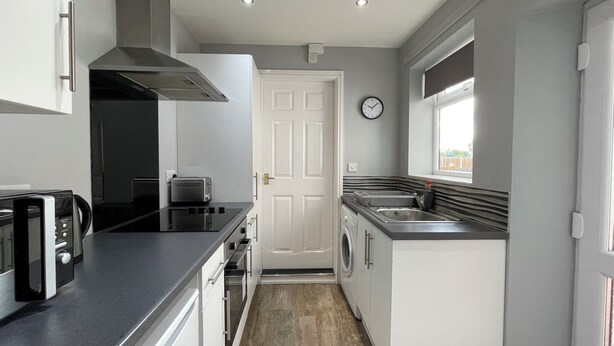 A compact kitchen with a microwave, toaster, and sink.