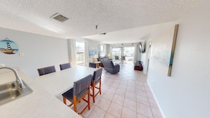 A spacious kitchen with a dining area, large windows, and a view of the city. - 3 Bedroom 2 Bath Beach View #205 Beach Place Condos (Madeira Beahc)