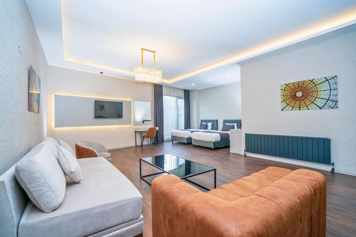 Ein modernes Wohnzimmer mit einer Couch, Hocker und einem Couchtisch.