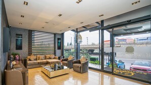 Um hall moderno com um sofá, poltronas e uma mesa de centro.