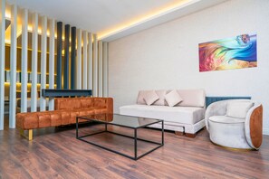 Habitación cuádruple superior | Área de sala de estar | Televisión LCD de 60 cm con canales vía satélite, Netflix y Hulu 