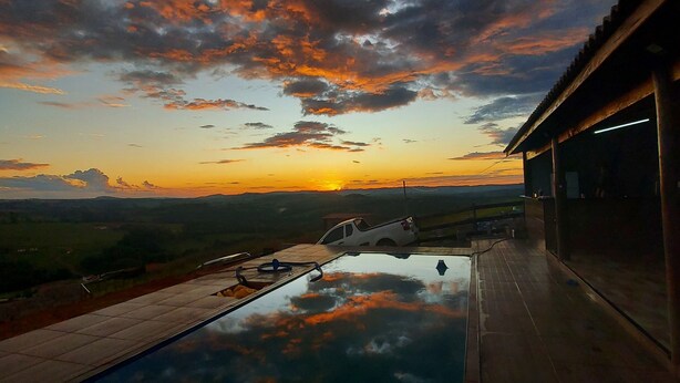 Ein Pool mit Blick auf einen Sonnenuntergang und die Ferne.