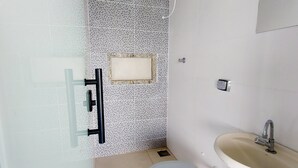 Ein kleines Badezimmer mit Toilette, Waschbecken und Dusche.