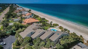 A coastal residential area with houses, a beach, and a swimming pool.