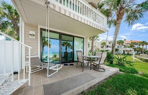 Ein Balkon mit Tisch und Stühlen, ein Schwimmbad und Meerblick.