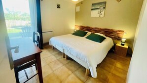 Un dormitorio con cama, mesita de noche, mesa y vistas al exterior.