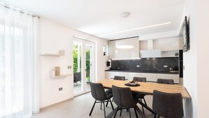 Eine moderne Küche mit Marmorarbeitsplatte, einem Holzespeisetisch und schwarzen Stühlen.