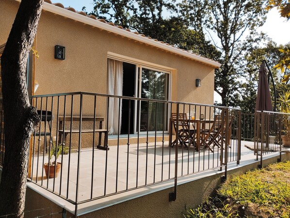A building with a balcony, a table, and chairs.