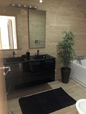 Chuveiro, banheira de hidromassagem, bidê, toalhas de banho