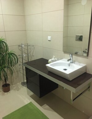 Chuveiro, banheira de hidromassagem, bidê, toalhas de banho