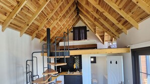 A compact, loft-style room with a wooden ceiling, a kitchenette, a sofa, and a staircase leading to an upper sleeping area. - Mayan Bungalows (Sapanca)