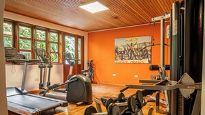 Un gimnasio con cintas de correr, elípticas y equipo de pesas.