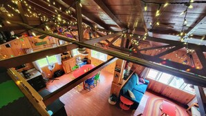 Una cabaña de madera de varios niveles con comedor, cocina y zona de estar.
