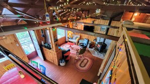 Interior acogedor de una cabaña con chimenea, paredes de madera y una zona de comedor.