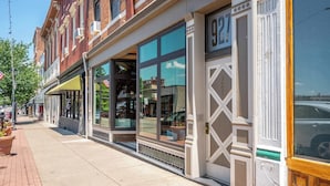 A row of brick buildings with large windows and a sidewalk.