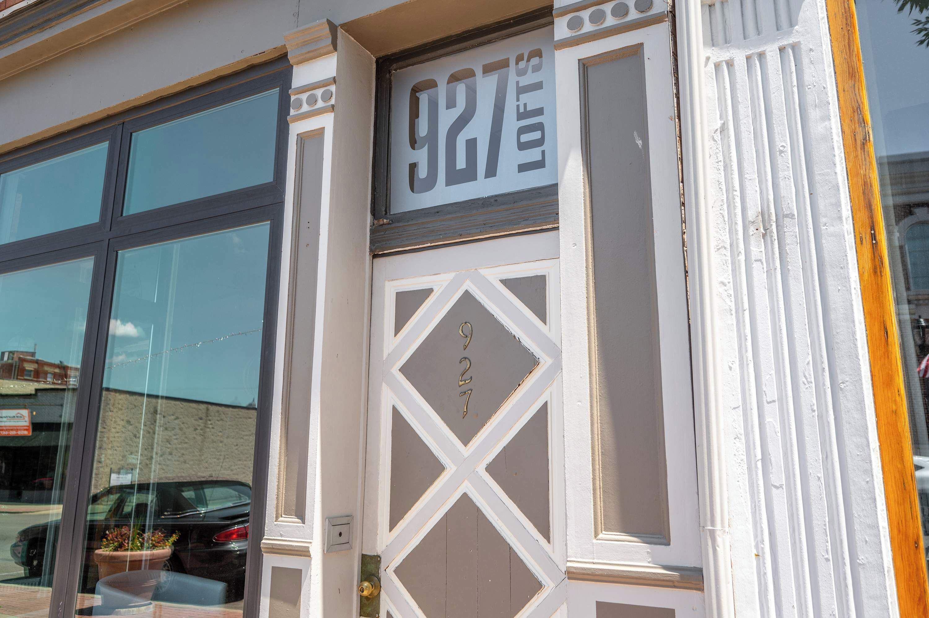 A building facade with a large window and a door with the number 927 visible.