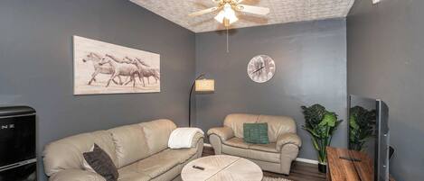 Apartamento, varias camas | Zona de estar | Una televisión