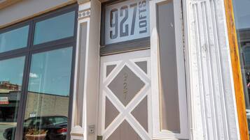 Fachada de edificio con un ventanal grande y una puerta donde se ve el número 927.