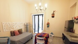 A compact living space with a bed, a dining table, and a kitchenette. - Encantadora Suite, en la Mejor Zona de Paseo Montejo. En el Barrio Gastronómico (Mérida)