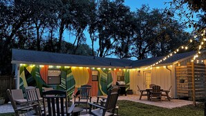 A backyard with a patio area, outdoor seating, and a barbecue grill. - Fire Pit/Golf Cart! 5 mins to Beach/DT! Fam Friendly! 4BR, 2 Kings! (Fernandina Beach)