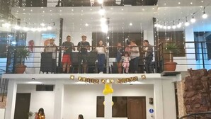 A group of people on a balcony with a sign that reads "Feliz Anno Nuovo". - Hotel San Isidro  (Pisco)
