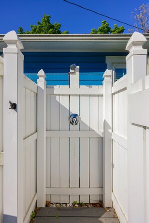 A white gate with a blue trim, a metal gate latch, and a small window above the latch. - Waterfront cottage in historic Charlestown, Maryland (Charlestown)