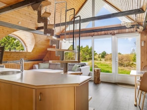 A modern kitchen with a large island, built-in appliances, and a view of the outdoors.