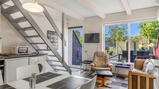 Eine moderne Küche mit Mikrowelle, Spüle und einer Treppe, die auf einen Balkon führt.