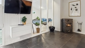 A modern living room with a flat-screen TV, a fireplace, and a large window. - "Tora" - 3km from the sea by Interhome (Rømø)